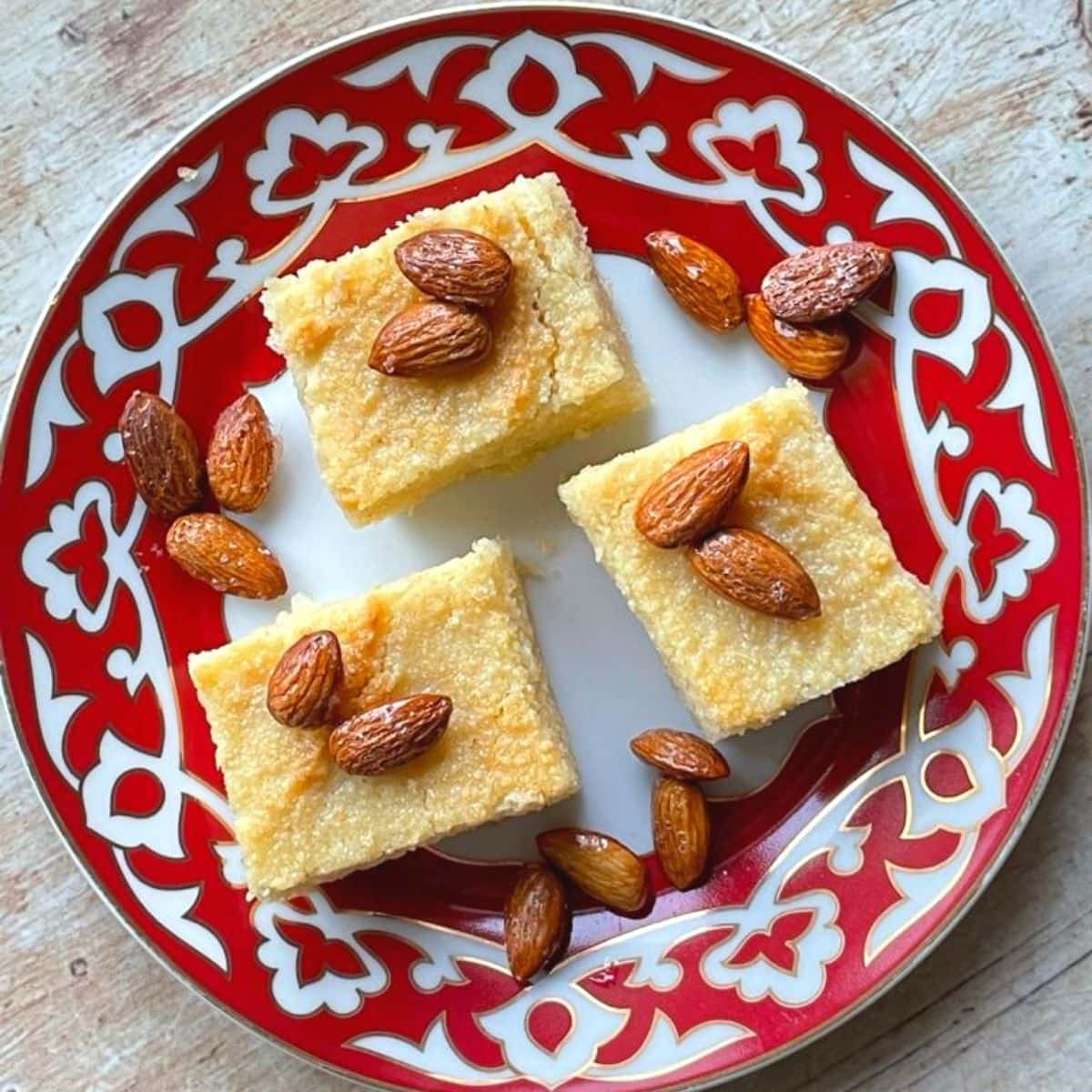 overhead view of three basbousa on red plate