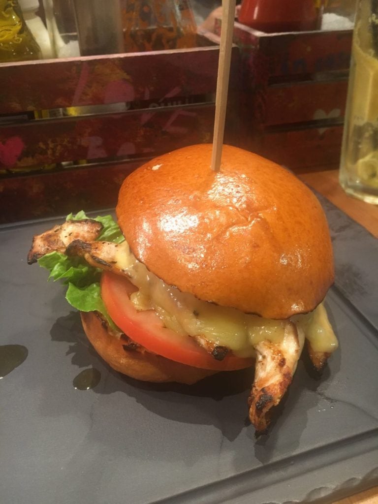 chicken burger with a wooden skewer through the top
