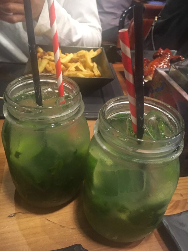 two mojitos in mason jars with paper straws