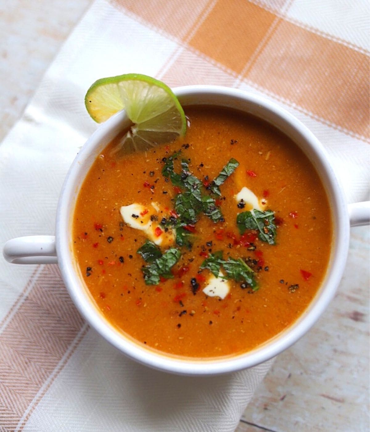Turkish lentil soup with mint and yogurt in white bowl.
