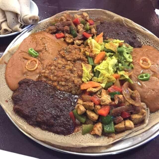platter of injera with portions of assorted mains