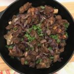 cooked lamb in iron skillet.