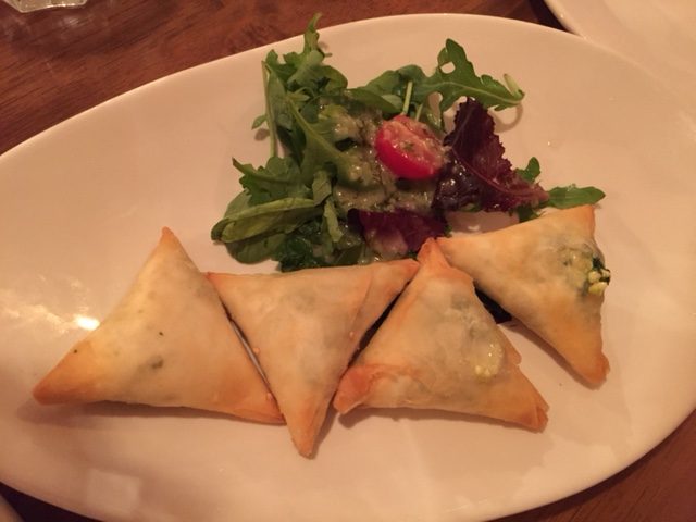  4 triangles of borek with a mini salad on a plate