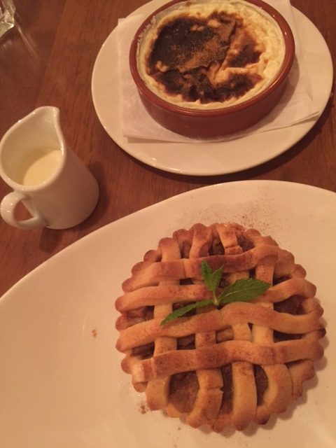 apple tart with a small jug of cream, and rice pudding