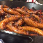 close up sausages and peppers in pan