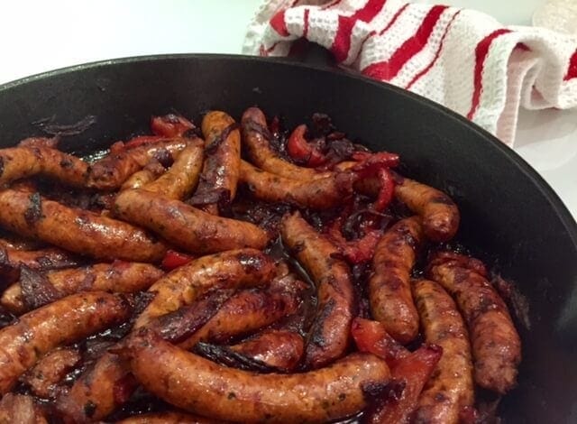 cooked sausages and red peppers in large cast iron skillet