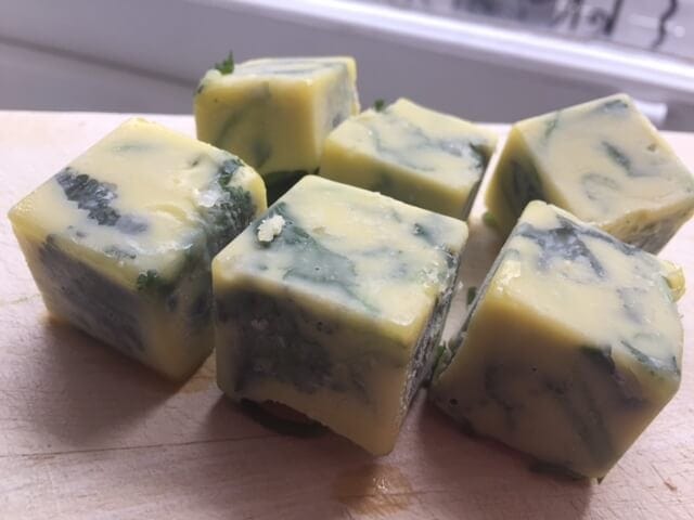 frozen cubes of herbs on wooden board