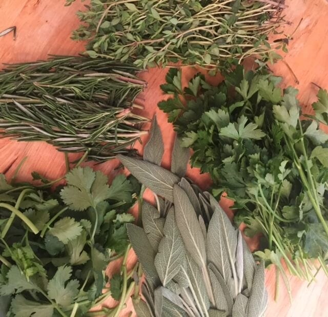 bunches of fresh herbs on a wooden board