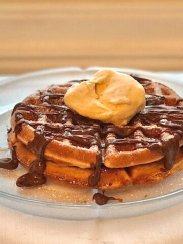 Image of two waffles covered in Nutella and a scoop of ice cream.