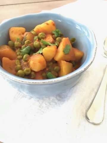 side view of bowl with curry next to silver spoon