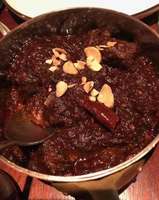 Closeup of a deep red Jaipur lamb dry curry 