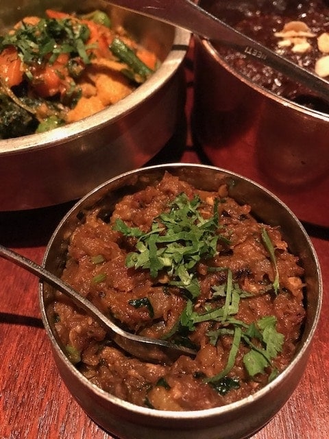 Baingan Barta in a small copper bowl with fresh coriander garnish