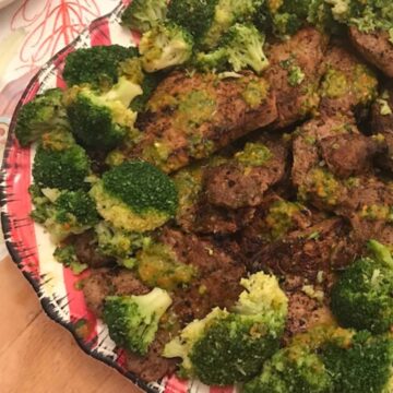 Image of platter of steak and broccoli with chimichurri.