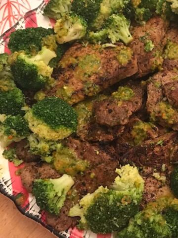 Image of platter of steak and broccoli with chimichurri.