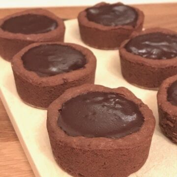 6 cookie cups filled with chocolate on wooden board