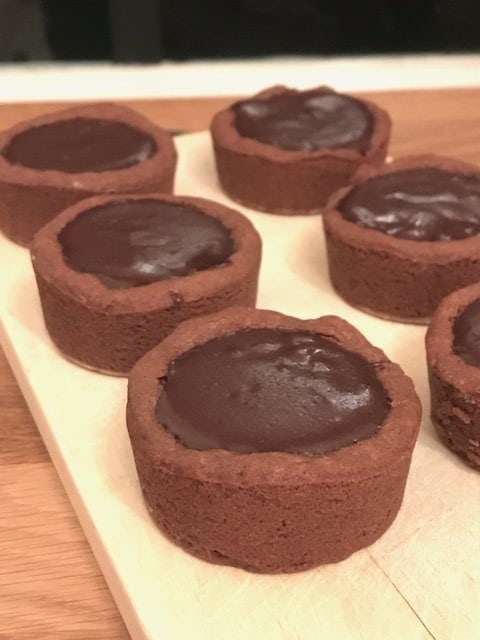 6 cookie cups filled with chocolate on wooden board