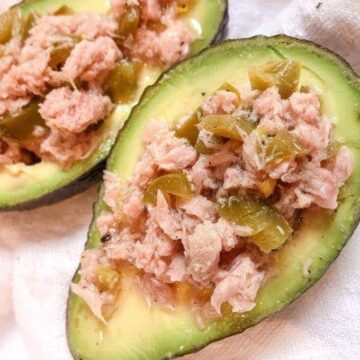 close up of 2 halves of avocado with tuna and jalapenos
