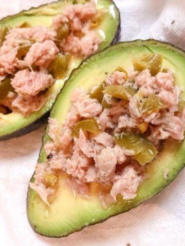 close up of 2 halves of avocado with tuna and jalapenos