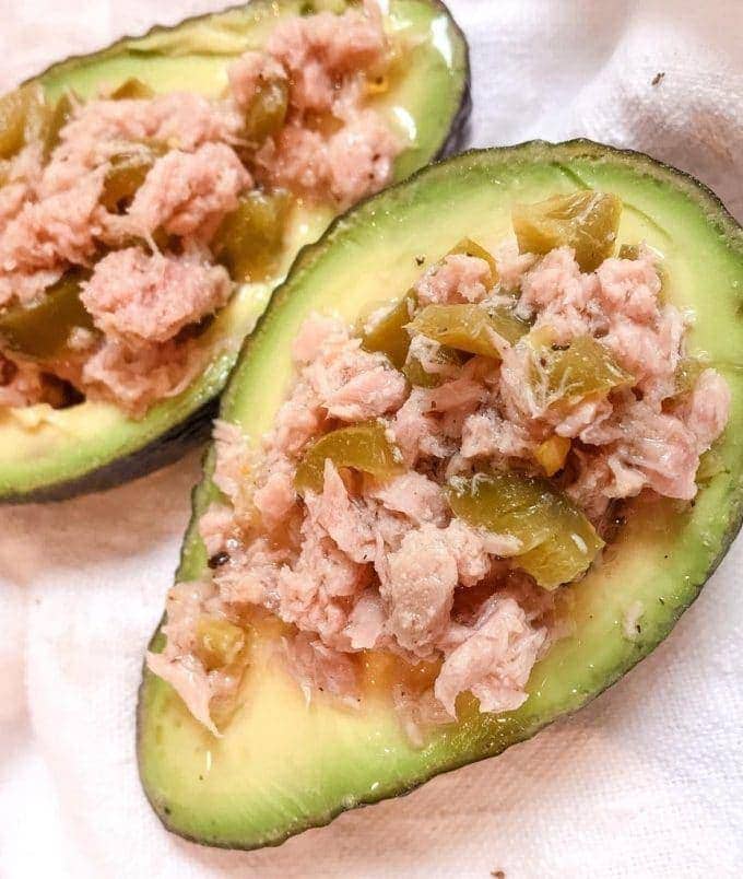 close up of 2 halves of avocado with tuna and jalapenos