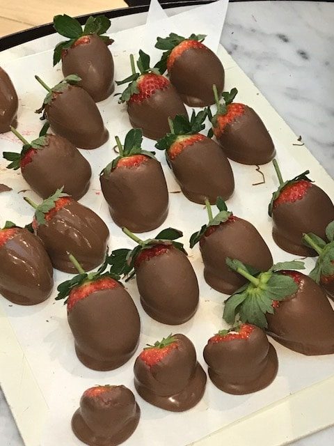 large stawberries dipped in chocolate on parchment paper