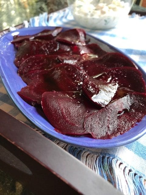 a plate of sliced beetroot with dressing