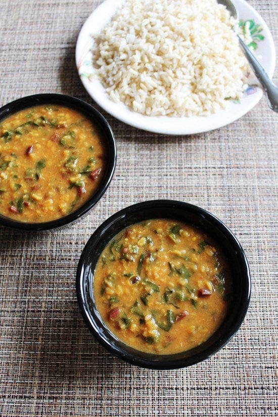 2 bowls of dal next to plate of rice