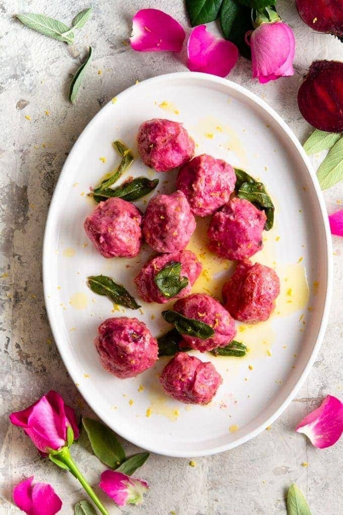 White plate with pink gnudi and sage leaves