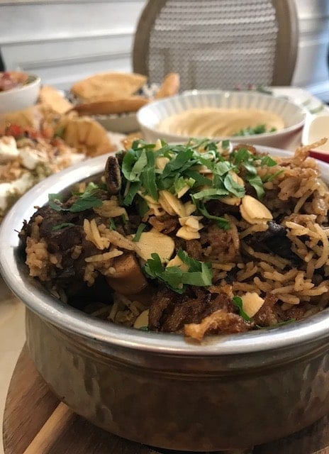 Bowl with maqluba sprinkled with sliced almonds