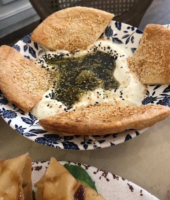 Labneh with oil and za'ater and bread with sesame, in a small bowl