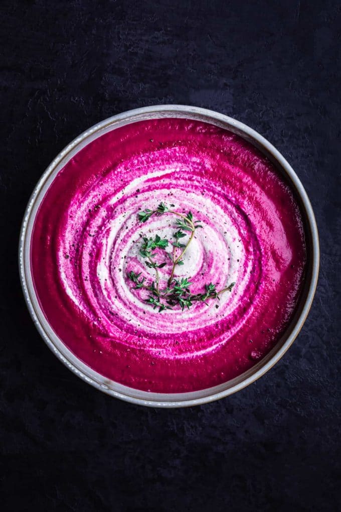 soup with white swirls and sprig of parsley