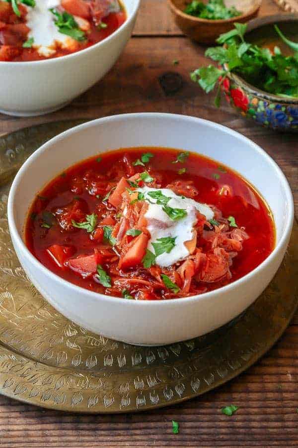 two white bowls of borscht soup