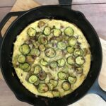 frittata in a skillet on a wodden board