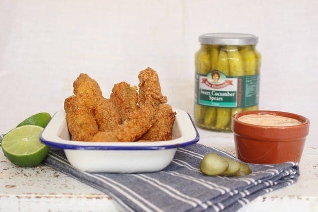 frickles in a bowl with a jar of pickles in the background