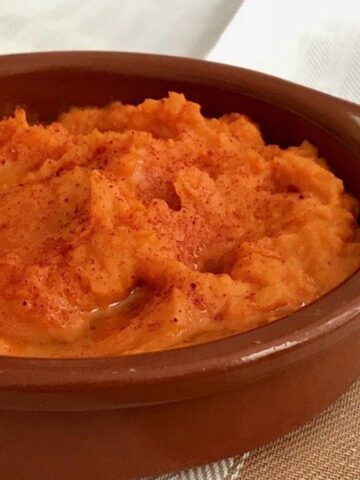 close up of hummus in a shallow terracotta bowl