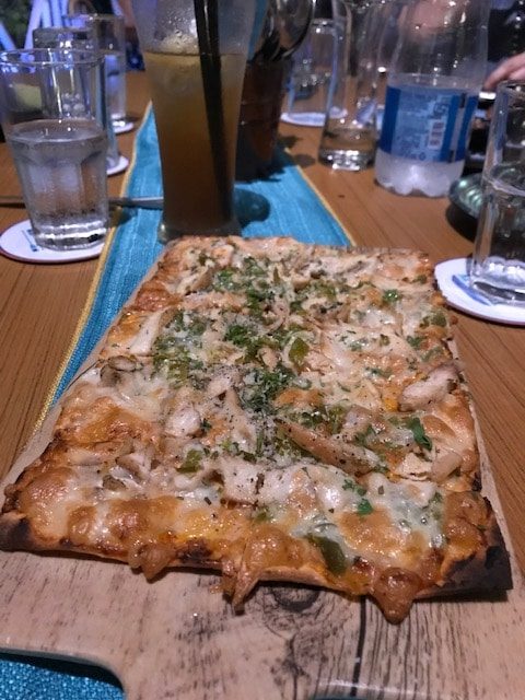 flatbread with pieces of chicken on a wooden board