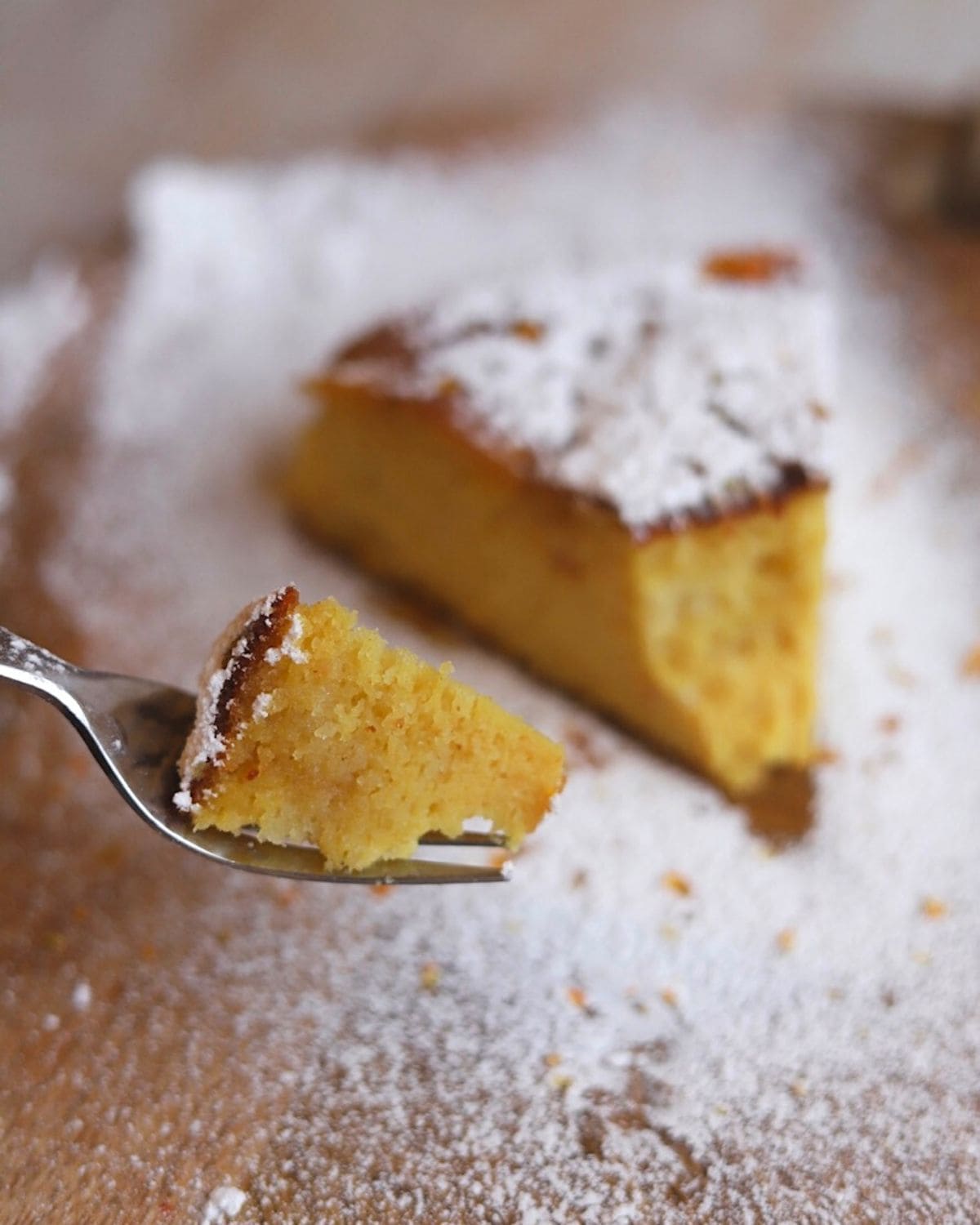 fork with piece of orange cake and slice in the background