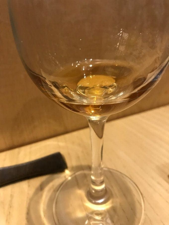 A small amount of kurozu vinegar in glass.