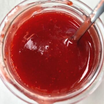 Image of strawberry coulis in a glass jar.