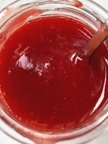 Image of strawberry coulis in a glass jar.