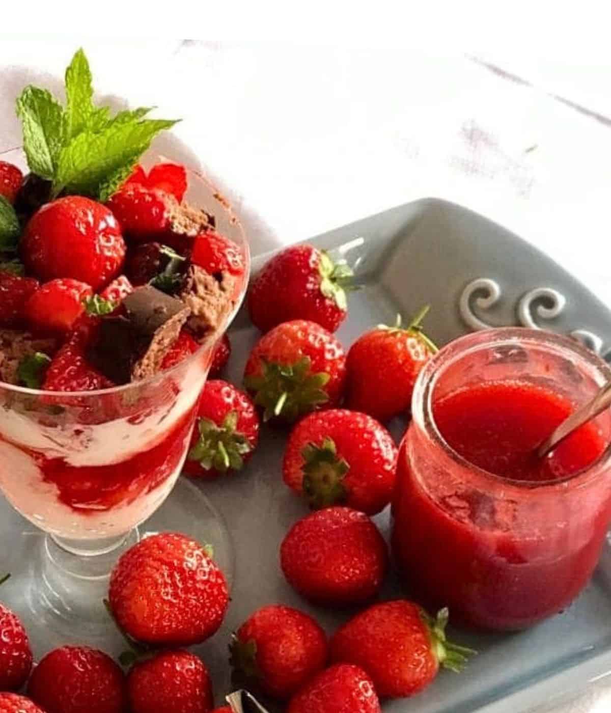 Strawberry coulis and strawberry dessert on a tray.