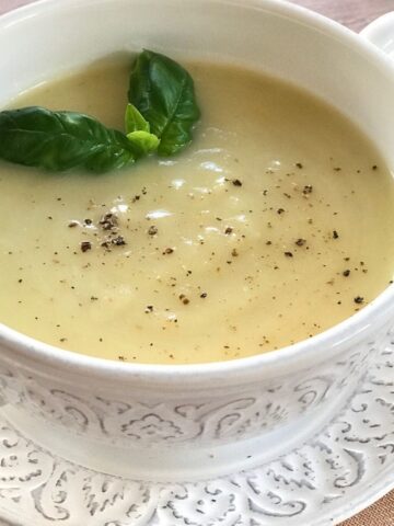 soup in white bowl with basil garnish