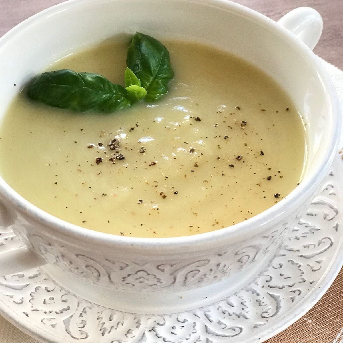 soup in white bowl with basil garnish