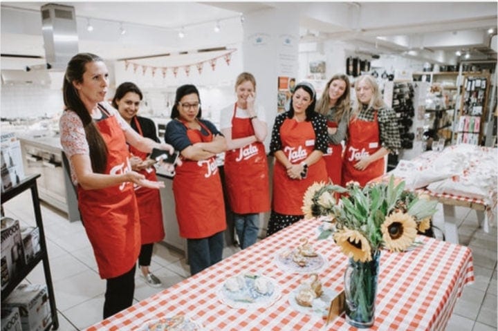 seven contestants facing table with completed pastry swans