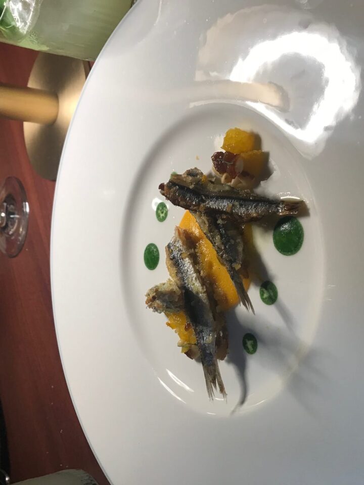 Fried anchovies on a large white plate