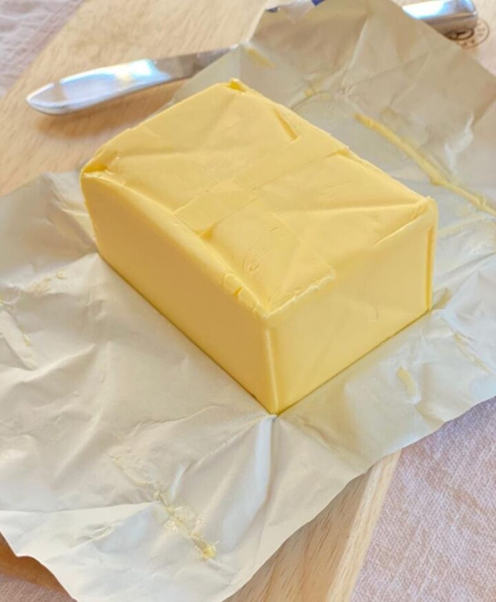 Block of unfrozen butter on a wooden board