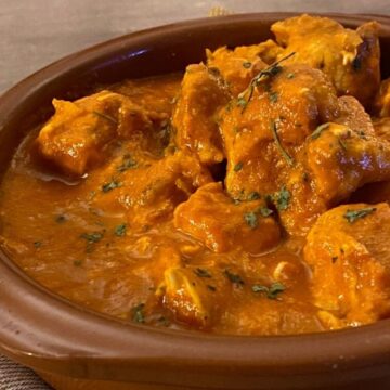 closeup of butter chicken in brown bowl