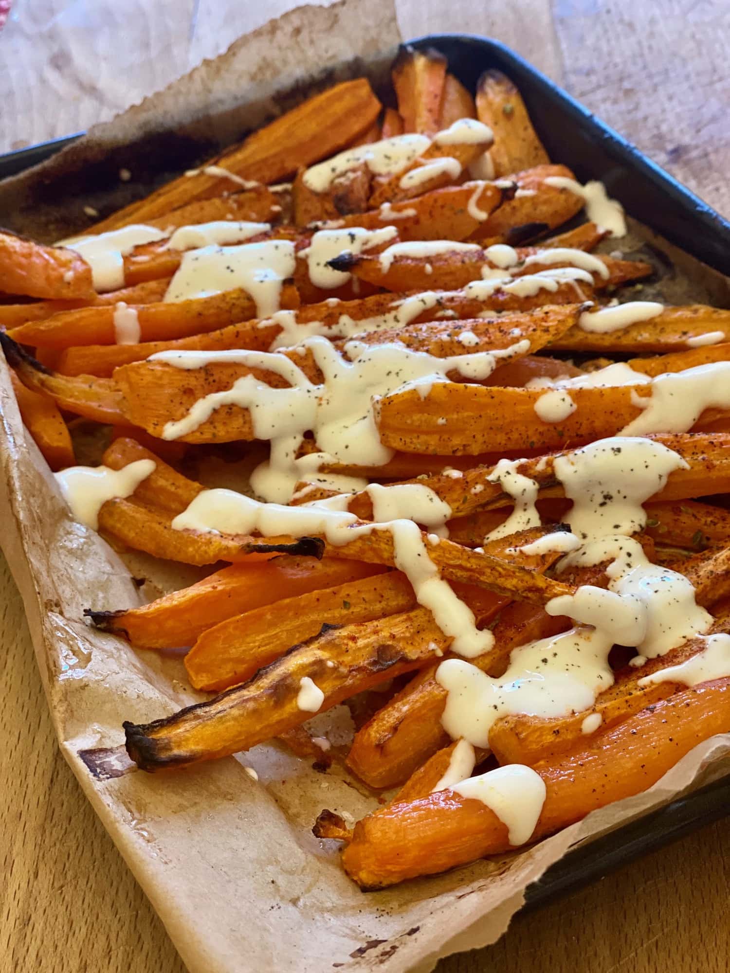 Roasted carrots with dressing on baking tray