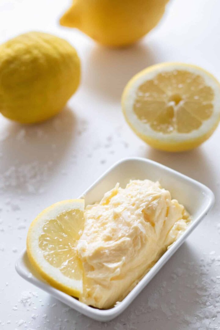 Image of whipped lemon butter in white dish with lemon slice.