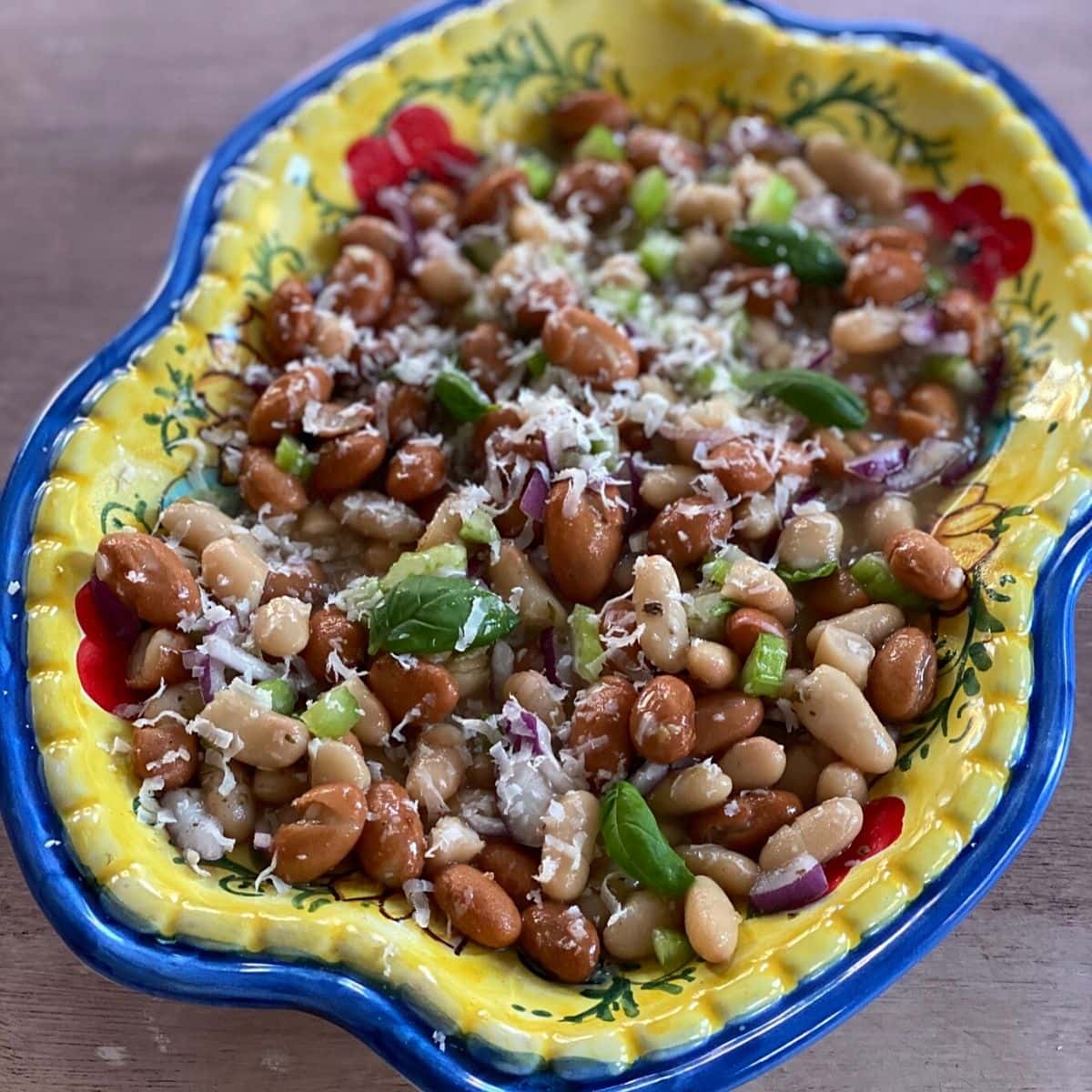 Bean salad on a colorful painted Italian ceramic plate.