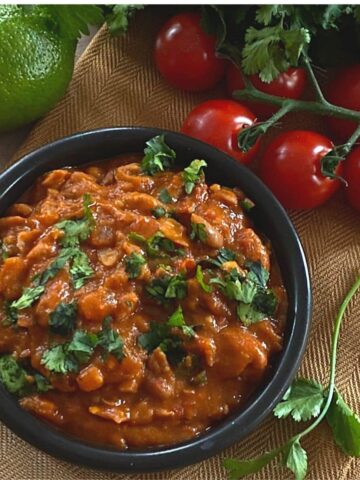 Pinto beans in small black bowl on table